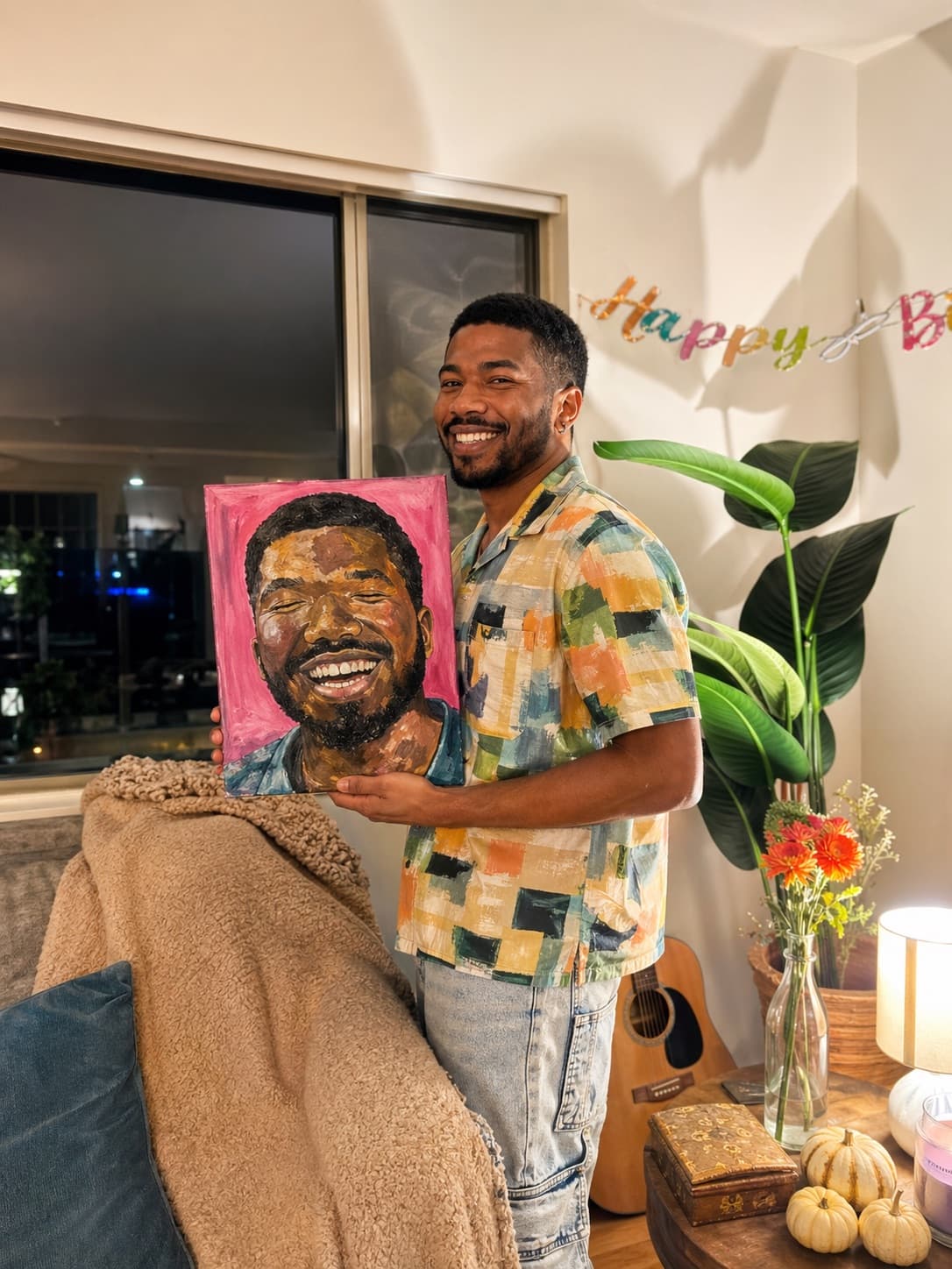 Smiling client holding a colorful acrylic self-portrait commissioned by Elena Marmol