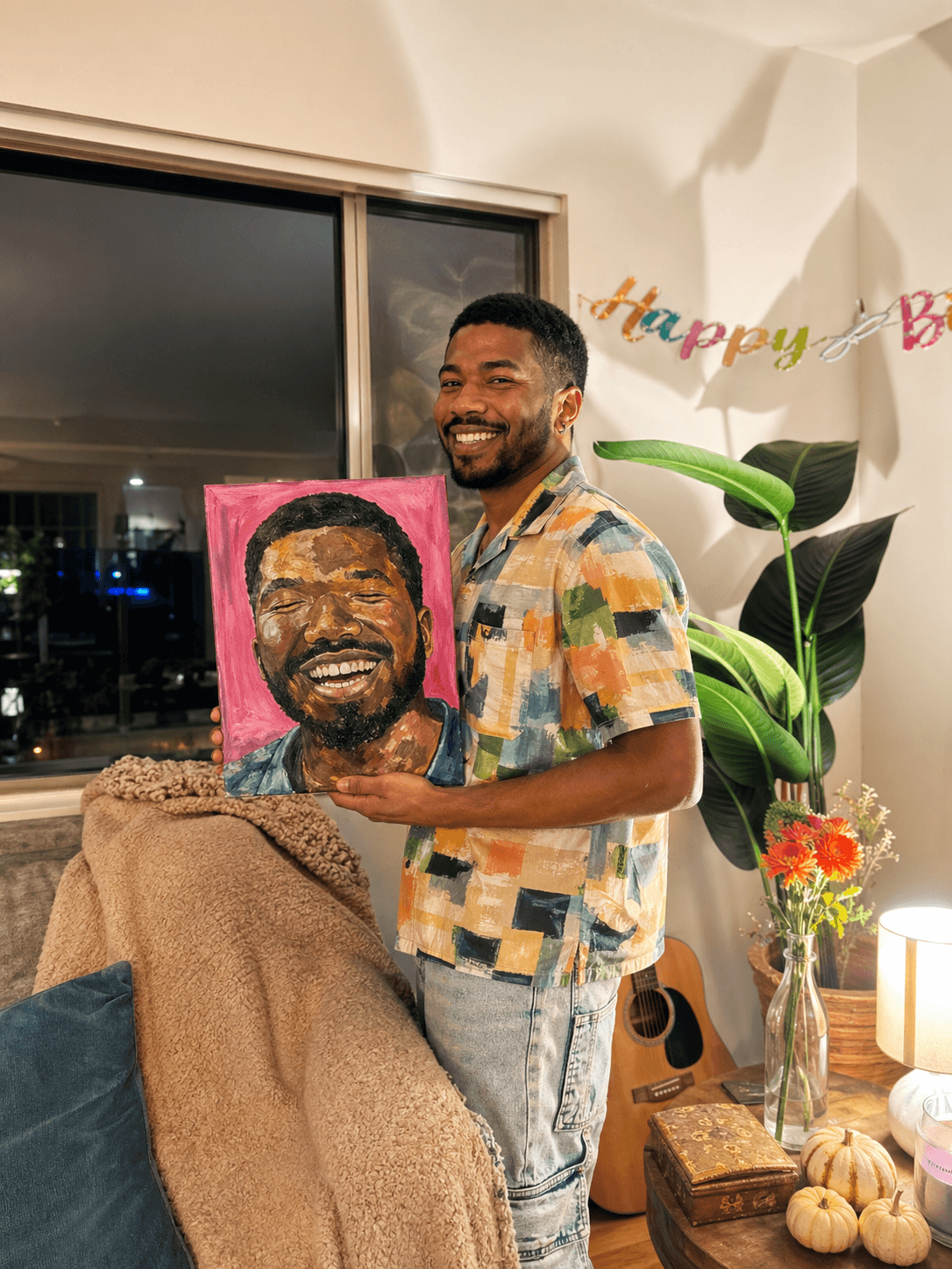 Smiling client holding a colorful acrylic self-portrait commissioned by Elena Marmol