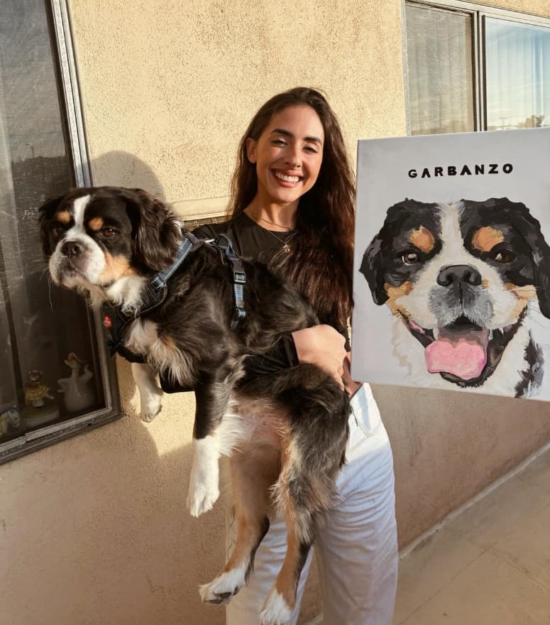 Hand-painted dog portrait shown alongside its subject