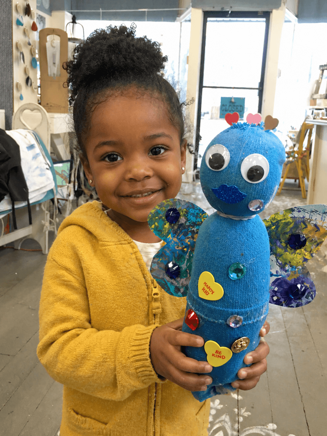 Young girl smiling with her art project — Eagle Rock backyard party