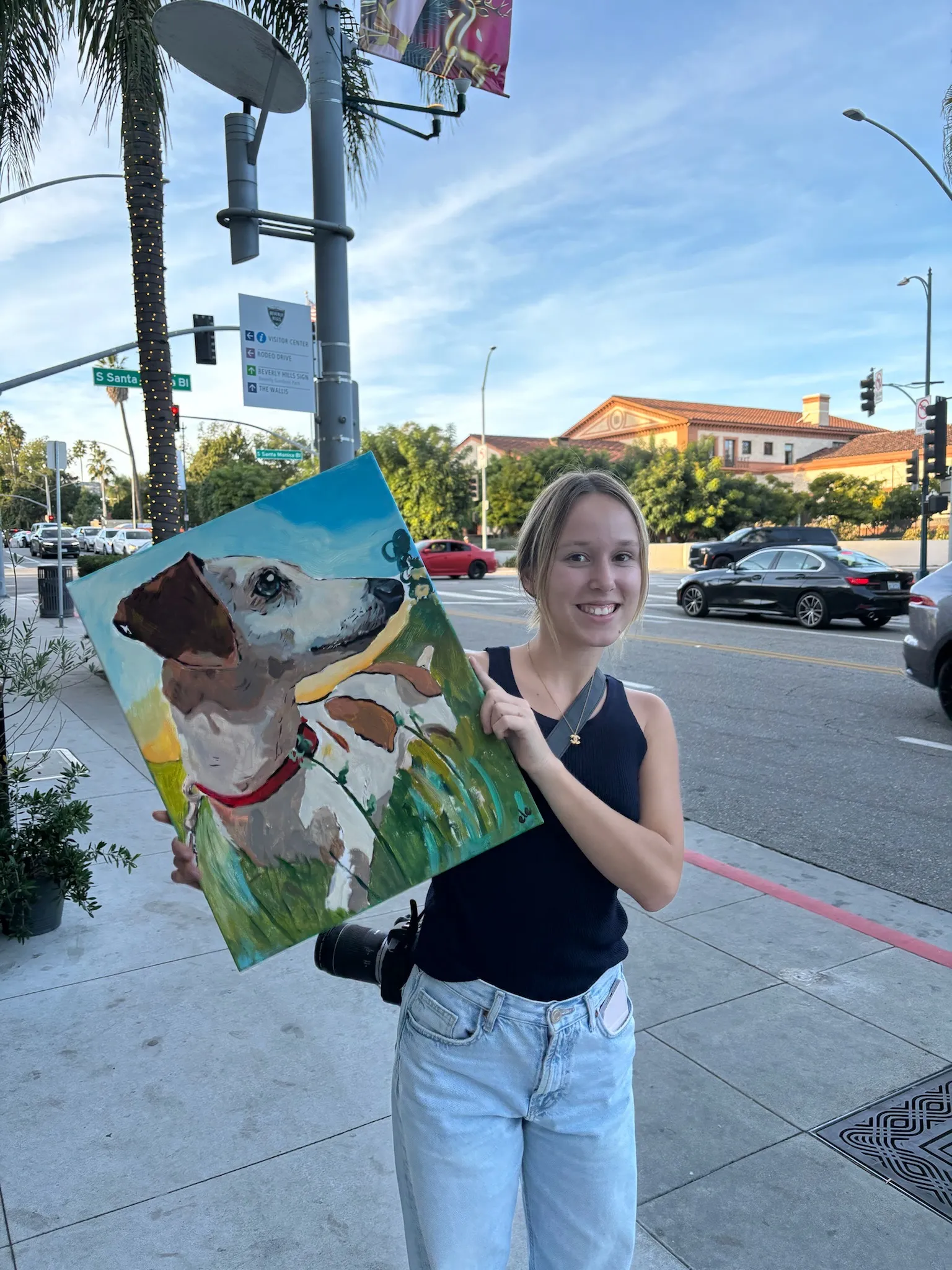 Client outdoors in Los Angeles holding a finished commissioned dog portrait