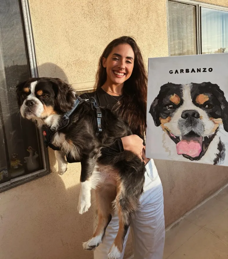 Hand-painted dog portrait shown alongside its subject